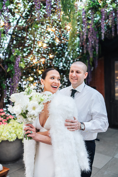 groom behind bride holding bouquet